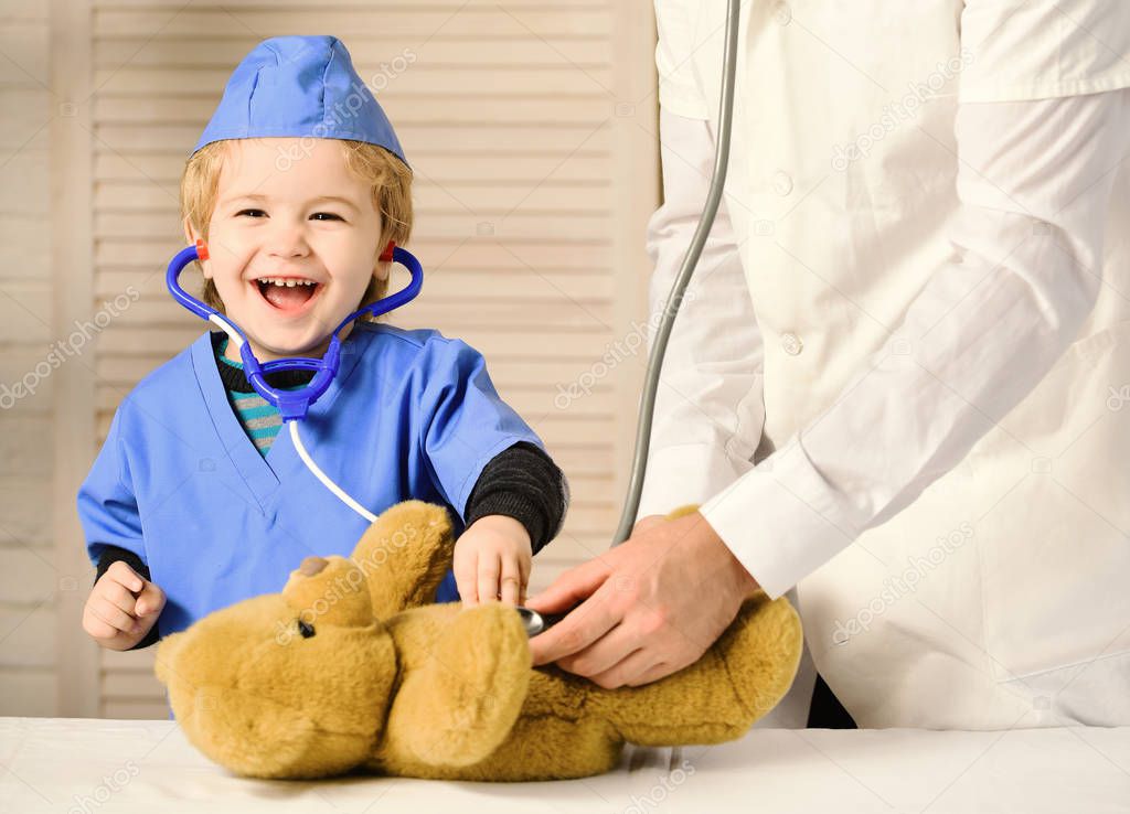 Health and childhood concept. Kid with happy face plays doctor
