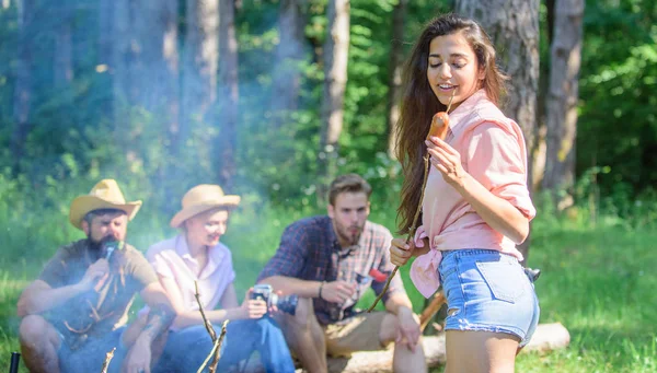 Weekend hike. Picnic with friends in forest near bonfire. Company having hike picnic nature background. Tourists with camera relaxing checking photos. Hikers sharing impression of walk and eating