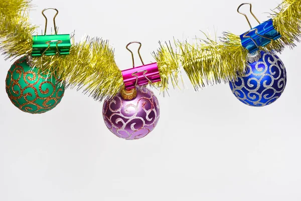 見掛け倒しでは、クリスマス ボールや飾り、白い背景、コピー領域に固定されています。キラキラ飾りボールはきらめく黄金見掛け倒しにしがみつきます。クリスマスの装飾の概念 — ストック写真