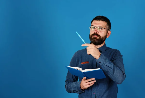 Homem com barba e óculos segura livro e marcador — Fotografia de Stock