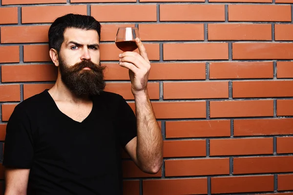 En kille med ett glas konjak. Man med skägg och mustasch — Stockfoto