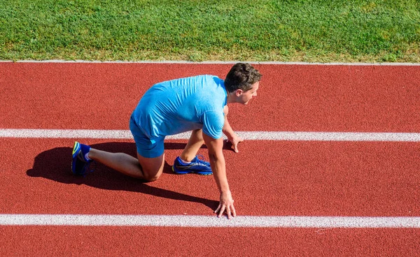 Man athlete stand low start position at stadium path. Beginning of new lifestyle habit. Runner ready to go. Athlete runner prepare to race at stadium. How to start running. Running tips for beginners — Stock Photo, Image