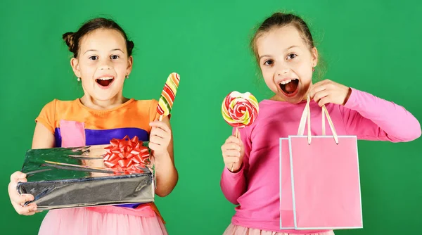 Los niños comen grandes caramelos dulces coloridos regalos de apertura — Foto de Stock