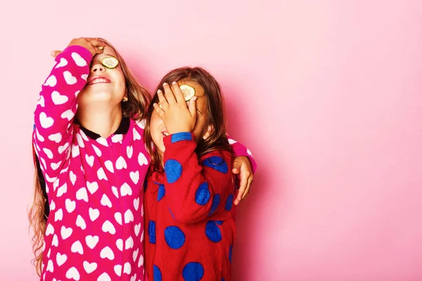 Meninas em polka colorido pontilhado pijama abraço e fechar os olhos — Fotografia de Stock