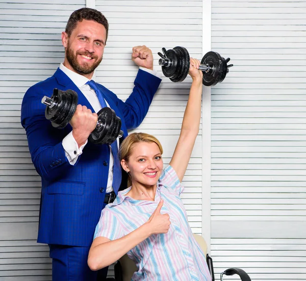 Strong business team. Healthy habits in office. Key to success concept. Strong powerful business strategy. Man and woman raise heavy dumbbells. Boss businessman manager raise hand with dumbbells