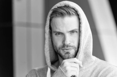 Düşünmeme izin ver. Adam düşünceli dokunuşlar kıl çene üzerinde sakallı. Düşünceli ruh kavramı. Kapşonlu adamla sakal veya tıraşsız adam yakışıklı görünüyor. Adam kıl ciddi yüz, kentsel arka plan, defocused