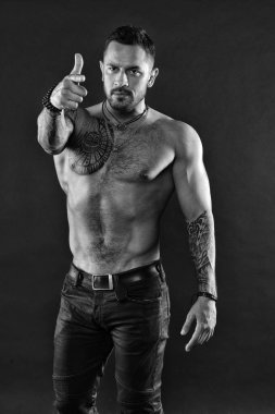 Dövme sanatı. Yakışıklı uygun tattoed adam ileriye dönük kot giymek. Kas dövmeli atlet göz çekici. Spor ve moda kavramı. Yakışıklı adam gömleksiz koyu arka plan üzerinde kot ile kas