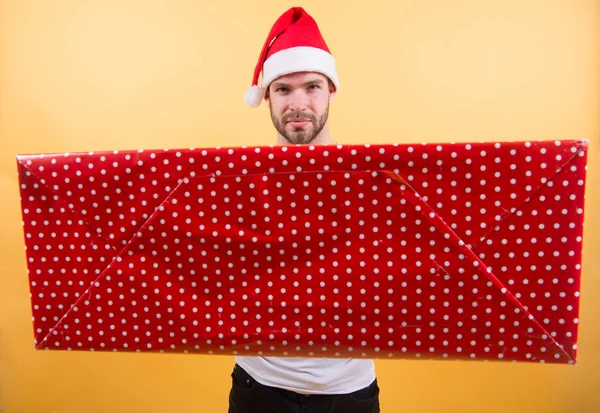 クリスマス ギフトの概念。サンタはあなたのためのギフトを持って来る。男の魅力的なサンタ クロースは、大きな箱を運ぶ。良い贈り物に値する。クリスマスの休日のお祝い。男ハンサムなひげを剃っていないサンタ帽子は、ギフト ボックスを保持します。 — ストック写真