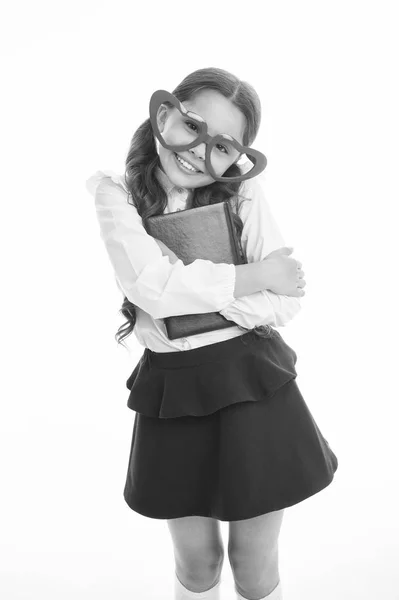 Дівчина милі великі окуляри у формі серця ізольовані на білому тлі. Дитяча шкільна форма одягу тримає книгу. Дитина носить шкільну форму розумного хлопчика, який посміхається обличчям. Повернутися до концепції школи. Милий і розумний — стокове фото