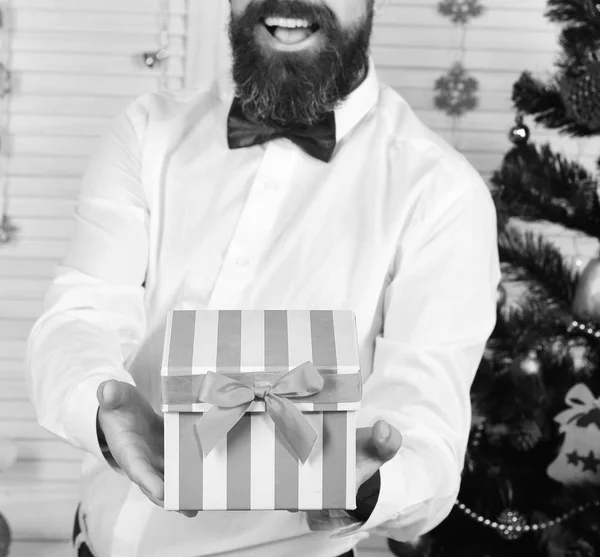 Guy near Christmas tree on wooden wall background — Stock Photo, Image