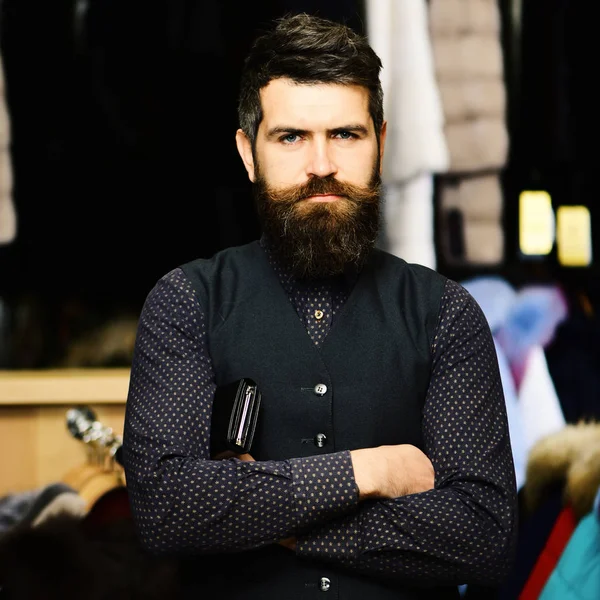 Man with confident face holds wallet on furry coat racks — Stock Photo, Image