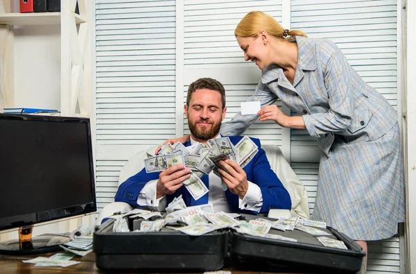 Bank assistant lady offers plastic card. Businessman with cash client of bank. Office manager administrator holds bank card. Credit loan and cash concept. Man business owner sit office pile of money