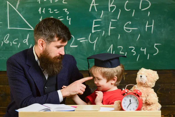 先生は、鏝板、背景に黒板の生徒。子供の注意欠陥を勉強しながら陽気な気が散る。担任の先生の息子は、小さな男の子、ひげの父します。いたずらっ子のコンセプト — ストック写真