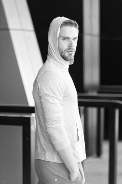 Adam sakallı ve çekici görünüyor geri kapşonlu. Kıl ciddi yüz, kentsel arka plan, defocused olan adam. Kapüşonlu adam sakal tıraşsız adam görünüyor yakışıklı. Yalnız kavram yürümeye. Yalnız kalmak gerekiyor