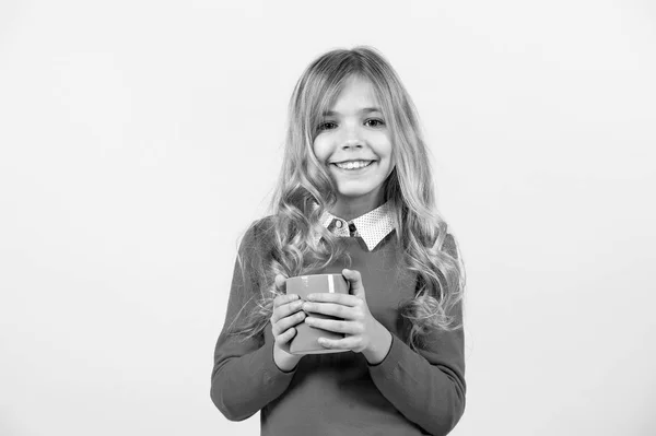 Sede, conceito de desidratação. Saúde e bebida saudável. Pausa para chá ou café. Menina com longos cabelos loiros em camisola vermelha segurar caneca. Criança sorriso com copo azul no fundo laranja. — Fotografia de Stock