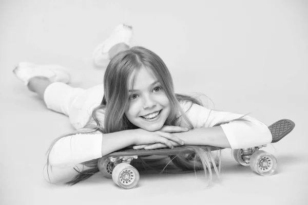 Concepto de pasatiempo para adolescentes. A la chica le gusta montar en monopatín y estilo de vida deportivo. Chica en la cara sonriente posando con tablero de penique, fondo rosa. Niña con el pelo largo listo para montar penny board — Foto de Stock