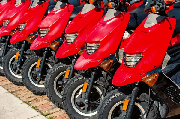 Röd skotrar eller motorcyklar till försäljning eller uthyrning i rad — Stockfoto