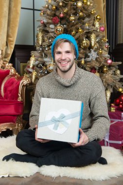 Hediye kutusu oturup Noel ağaç adam gülümseyerek
