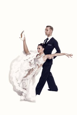 Dans eden balo çifti beyaz sahilde yalnız poz veriyor.