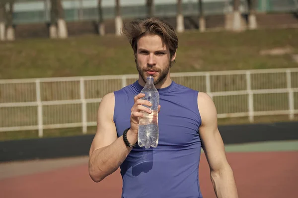 Красивий м'язистий чоловік тримає пляшку води — стокове фото