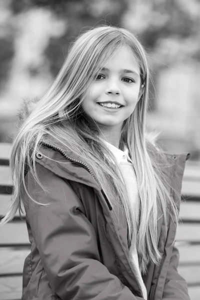 Lazer, relaxamento, estilo de vida Modelo infantil sorrindo com cabelo comprido. Menina com sorriso adorável no fundo escuro. Feliz conceito de infância. Salão de beleza e cabeleireiro . — Fotografia de Stock