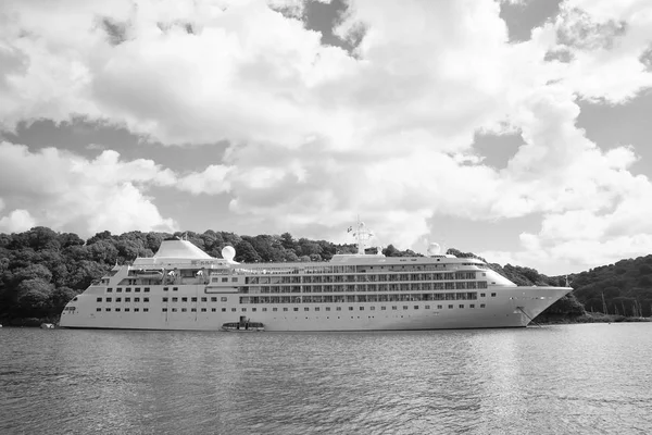 Cruise ship at seacoast in Fowey, United Kingdom. Ocean liner in sea on cloudy sky. Summer vacation on tropical island. Travelling by water with discovery. Wanderlust and adventure — Stock Photo, Image