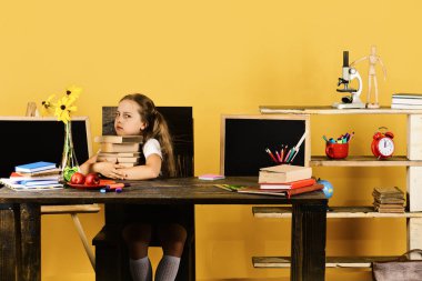 Huysuz yüz ile kız öğrenci kitap yığını tutan