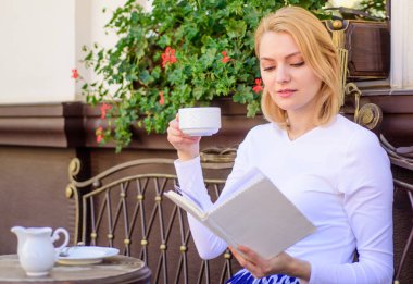 Kız içki kahve her sabah saat aynı yerde günlük ritüel. Kadın açık havada içki kafe teras vardır. Kitap kurdu eğlence kavramı. İyi kahve ve keyifli kitap en iyi kombinasyonu mükemmel hafta sonu için bir fincan