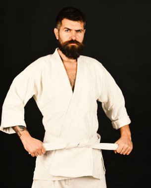 Siyah arka planda beyaz kimonolu sakallı adam..