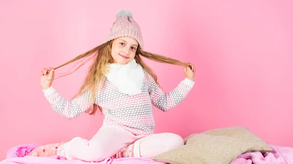 Acessório de moda de inverno para criança. Conceito de acessório de inverno. Menina jogar cabelo longo fundo rosa. Kid sorrindo desgaste de malha acessório. Menina criança vestir bonito tricotado chapéu elegante e cachecol acessório — Fotografia de Stock