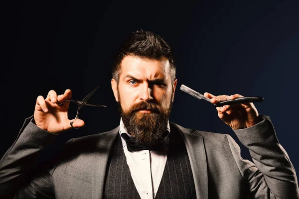 Homem com barba comprida segura lâmina de barbear e tesoura. — Fotografia de Stock