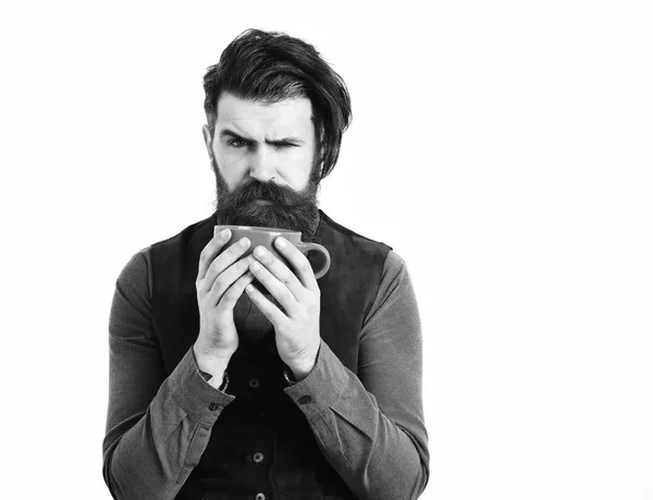 Бородатый мужчина держит чашку с кофе, чай с сердитым лицом — стоковое фото