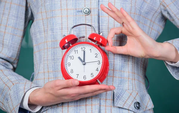 Lehrerattribute. Wecker in den Händen des Lehrers oder Pädagogen Klassenzimmer Hintergrund. Schuldisziplinarkonzept. Zeitplan und Regime. Pünktlich, ok Geste. Wecker in Frauenhänden schließen — Stockfoto