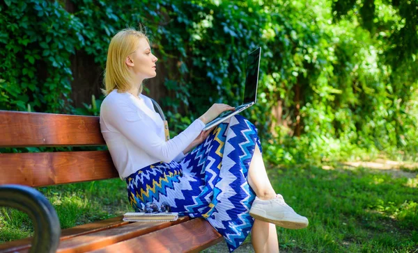 Lady freelance che lavora nel parco. I lavori remoti sfogliano le migliori opportunità di lavoro remoto freelance. Donna con computer portatile lavora all'aperto sfondo verde natura. Ragazza sedersi panchina con notebook alla ricerca di un nuovo lavoro — Foto Stock