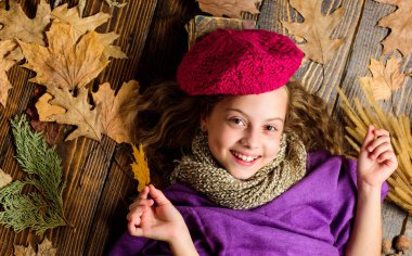 Sonbahar moda aksesuar kavramı. Moda trend sonbahar sezonu. Kız yatıyordu ahşap arka plan yaprakları yukarıdan düşmüş. Aksesuar moda ayrıntı ördü. Küçük çocuk kız parlak yumuşak örme şapka bere moda