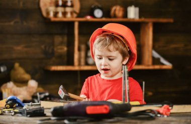 Heyecanlı çocuk çekiç ile oynuyor. Atölyede yardım çocuk. Küçük çocuk pratik marangoz becerileri