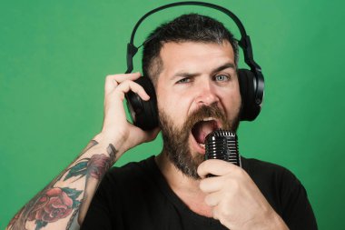 Sakin ol ve müzik konsepti. Adam yeşil arka plan üzerinde şarkı söylüyor..