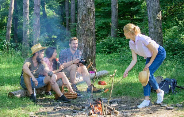 Summer picnic. Tourists hikers sit on log relaxing waiting picnic snack. Company having hike picnic nature background. Picnic with friends in forest near bonfire. Hikers relaxing during snack time
