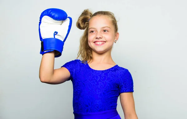 Sport upbringing for girls. Feminist movement. Strong child concept. Kid strong and healthy. Girl child strong with boxing gloves posing on grey background. She feels strong and independent girl — Stock Photo, Image
