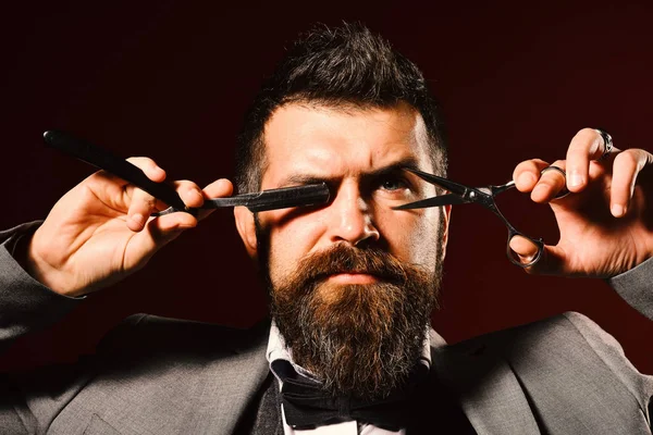 Koyu kırmızı arka planda katı yüzlü bir iş adamı..