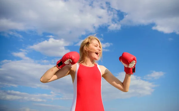Woman strong boxing gloves raise hands blue sky background. Girl boxing gloves symbol struggle for female rights and liberties. Feminism promotion. Fight for female rights. Girls power concept