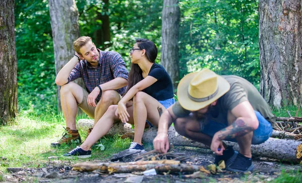 Company friends camping forest. Man brutal bearded hipster prepares bonfire in forest. How build bonfire outdoors. Camping weekend leisure. Ultimate guide to bonfires. Arrange woods twigs or sticks