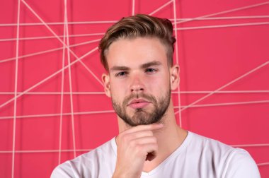 Doğru ürün stili saç kullan. Kendine güvenen, düzgün saç stili olan. Berber saç stili ipuçları. Sakallı adam, modern saç stili, düşünceli, pembe arka plan. Saç modelini daha iyi yapmak için basit hack 'ler.