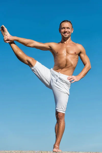 Bereikte evenwicht. Meditatie en yoga concept. Yoga helpt evenwicht vinden. Praktijk asana buiten. Yoga praktijk helpt vinden harmonie en balans. Man praktizerende yoga blauwe hemelachtergrond — Stockfoto