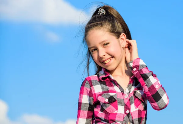 Miúdo elegante e elegante. Conceito de moda infantil. Menina menina xadrez camisa elegante posando dia ensolarado azul céu fundo. Criança bonito menina cabelo longo rabo de cavalo cabelo. Menina modelo de moda — Fotografia de Stock