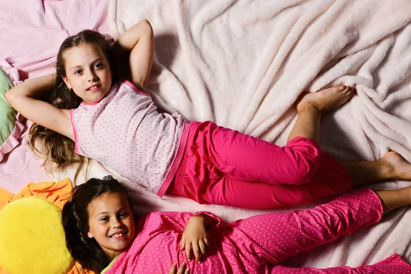 Kids with smiling faces have rest in bed — Stock Photo, Image