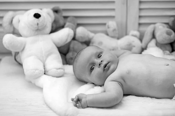 Младенец с голубыми глазами и удивленным лицом на светлом одеяле — стоковое фото