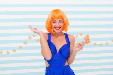 Oyuncu modunda çılgın bir kız. Lolipopu olan havalı bir kız. Seksi bir kadın. Turuncu saçlı moda kızı eğleniyor. Elinde lolipop olan mutlu poster modeli. Hoş görünüş. Deliriyorum. Çok eğlenceli. İyi eğlenceler.