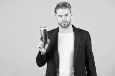 Kendine güveni olan adamın elinde şampuan şişesi, gri bir arka plan var. Tüylü adam şampuan tutuyor, fotokopi uzayı. Erkekler saçlarını şampuanla yıkadıktan sonra tazeliğin tadını çıkarırlar. Saç bakımı ve güzellik malzemeleri konsepti