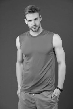 Kendine güvenen sporcu. Adam yakışıklı giyim menekşe arka plan spor. Sporcu atlet emin ellerini cebine koyar. Erkeklik ve güven kavramı. Sporcu spor grubu akıllı saati ile